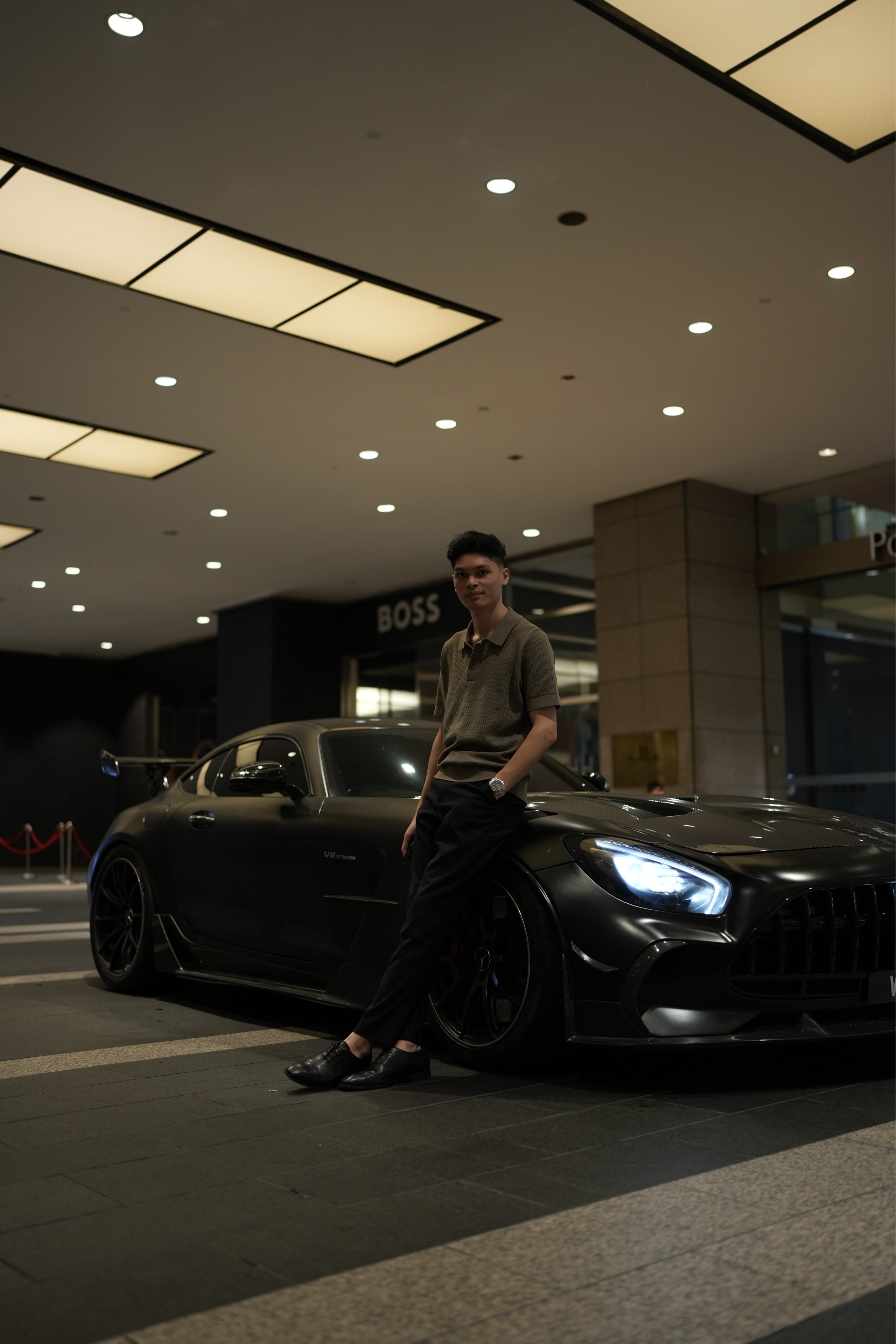Gary standing beside a black sports car